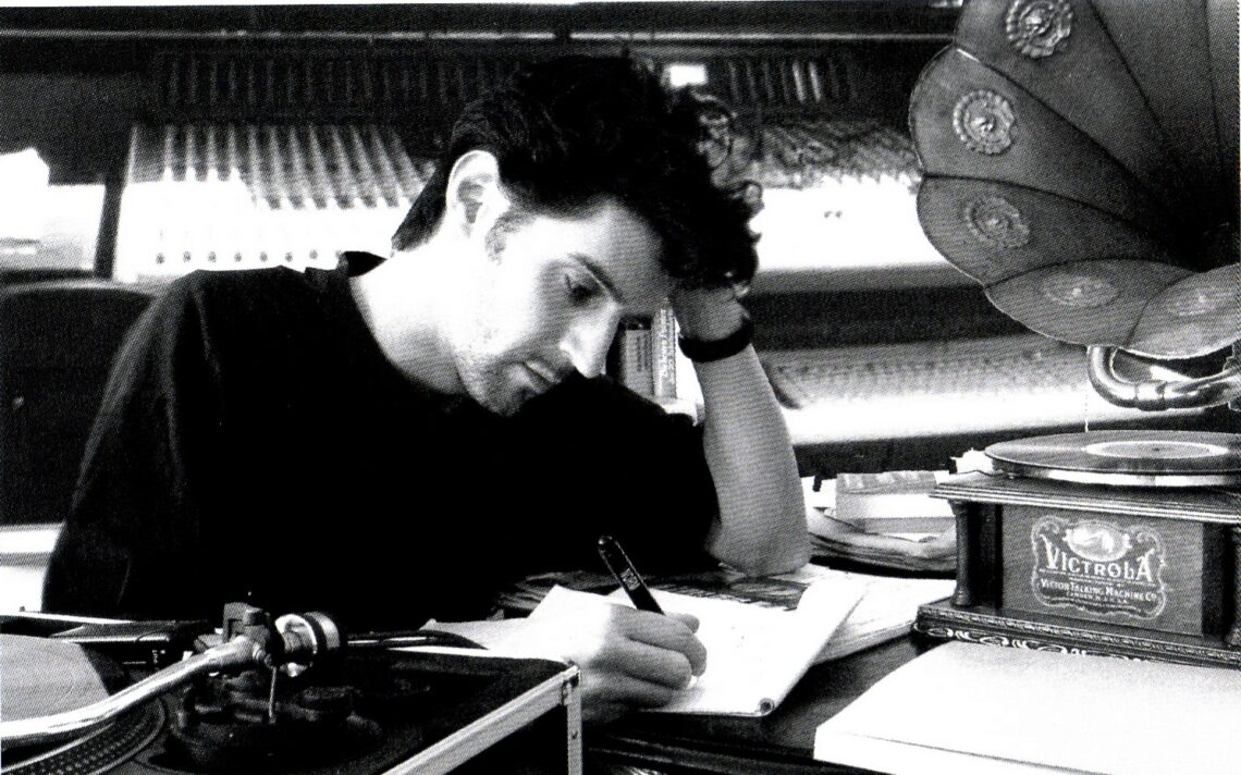 Roger Stein am Schreibtisch im Studio, neben einem Victrola-Grammophon