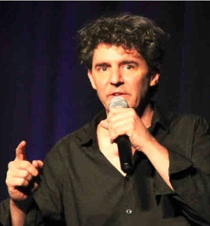 Roger Stein mit Mikrofon und erhobenem Zeigefinger – Haus der Begegnung Grenzach 2024