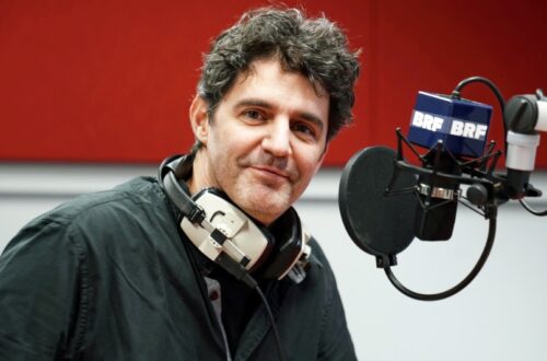 Roger Stein mit Kopfhörern am Mikrofon im Studio von BRF1