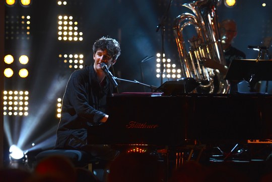 Roger Stein singt live am Blüthner-Flügel, im Hintergrund ein Tubist