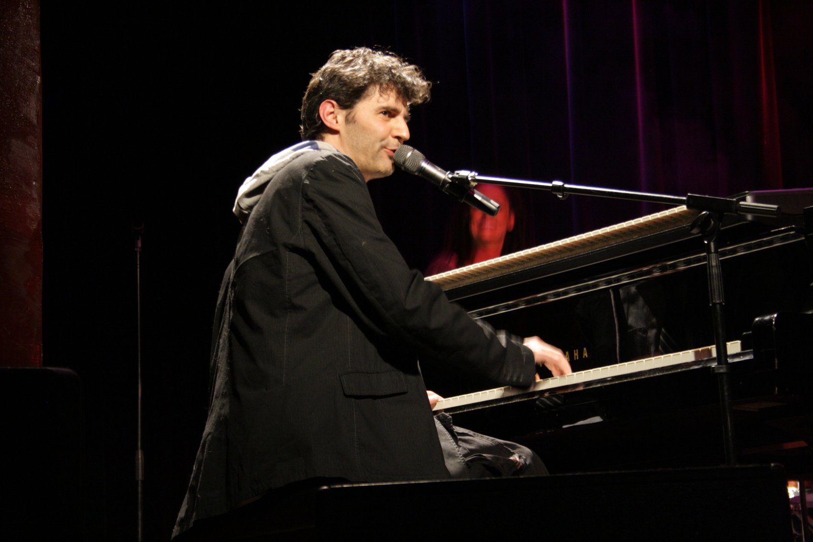 Roger Stein singt am Flügel ins Mikrofon